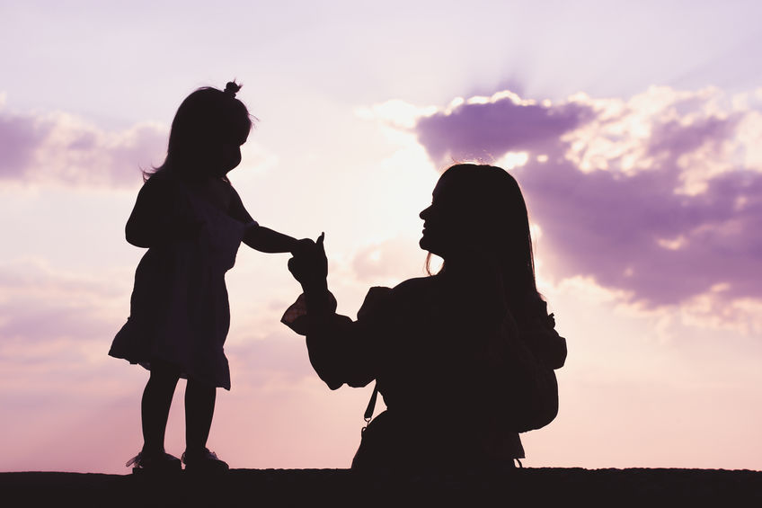 A woman holds the hand of her daughter after winning a child custody case with the help of private investigation services