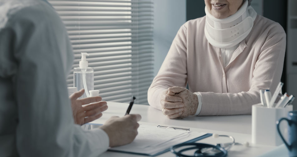 A claimant smiles as she sits across the table from an insurance adjuster while our private investigation services surveillance investigator is ready outside.