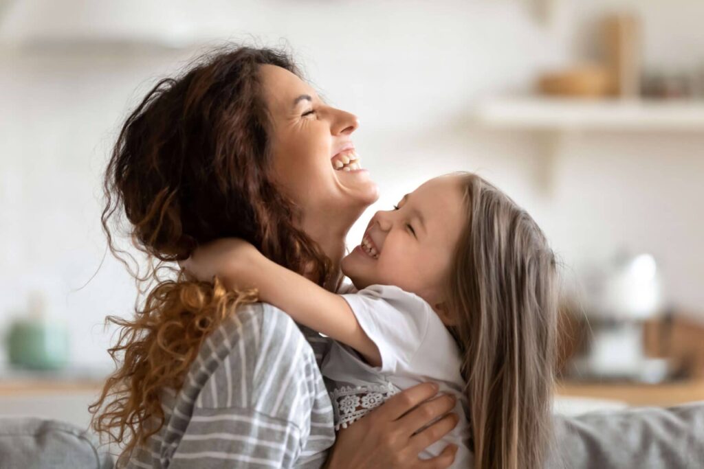 A mother smiling with her daughter after gaining custody after a child custody investigation.