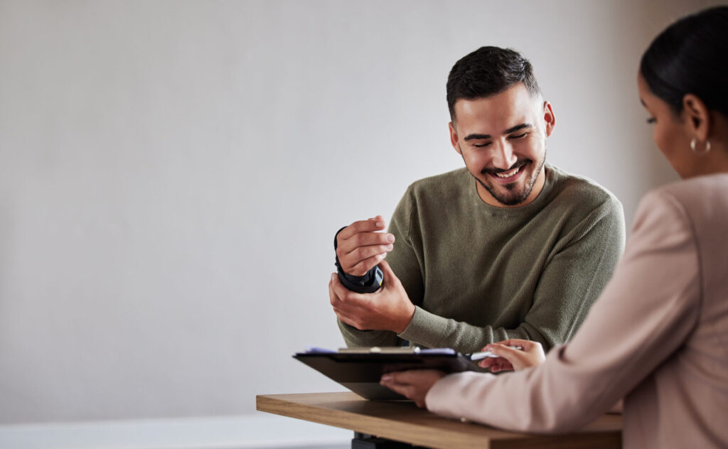Surveillance services for combating fraudulent insurance disability claims as a claimant smiles and holds his wrist while while seeing the amount of his settlement.