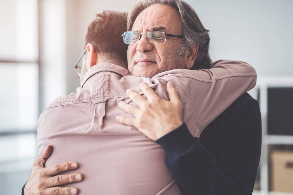 Father and son reuniting after a successful skip tracing investigation