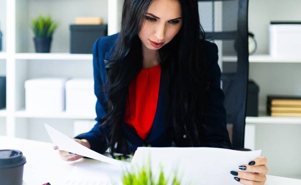 Background Check private investigator analyzing data for Guardianship, Child Custody, Family Law Case while seated in an office.